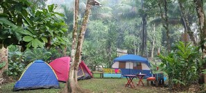 Un camping con varias tiendas de campaña, una mesa y sillas.