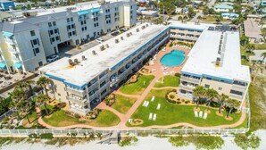 A multi-story hotel with a rooftop pool, outdoor seating areas, and a landscaped courtyard.