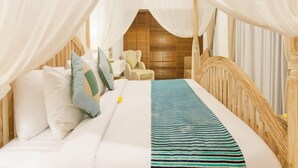 Ein Bett mit weißer Bettwäsche, einer gestreiften Decke, einem Holzkopfteil und einem Baldachin.