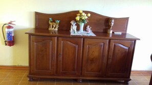 A stylish cabinet with a curved top and a vase with flowers adds a touch of elegance to the room.