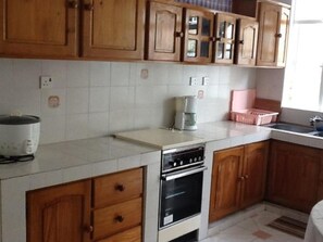 Kitchen features an oven, coffee maker, and sink area.
