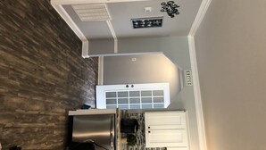Una cucina con un frigorifero in acciaio inox, un forno bianco e una parete di fondo decorata con un motivo a griglia.