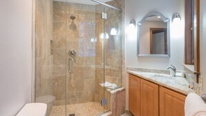 A modern bathroom with a glass-enclosed shower, a marble-tiled shower area, wooden cabinets, and a large mirror above the sink. - 1 Block to Lift 7 | Walk to Downtown Telluride | Views, Hot Tub, Parking (Telluride)