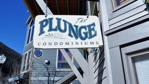 Une enseigne indiquant « The Plunge Condominiums », avec une vue dégagée sur la façade de l’immeuble.