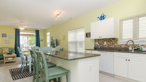 A modern kitchen with white cabinets, a granite countertop, and a built-in dishwasher. - Townhome 2 blocks from beach. Sleeps 10! (Carolina Beach)
