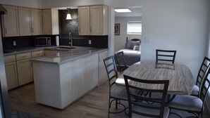Una cocina moderna con una isla central, una mesa de comedor y sillas.