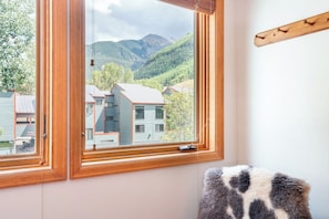 A room with a large window overlooking a mountain landscape.