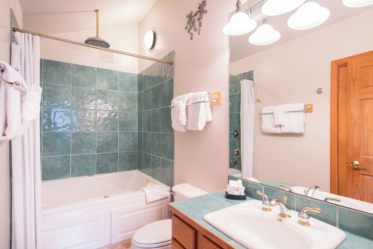 Une salle de bain avec une baignoire, des toilettes, un lavabo et un miroir.