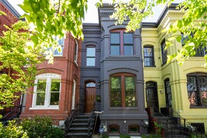 A row of three-story townhouses with a central entrance, a visible fire escape, and a small garden area. - Gorgeous 4 BR/3.5 BA Rowhous U. Steet Area  With All New Furnishings!! (Washington)