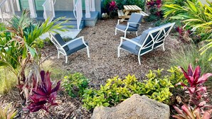 A patio area with outdoor seating and a variety of plants.