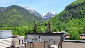 A rooftop terrace with a table and chairs, overlooking a mountainous landscape. - Willow 302 2 Bedroom/2 1/2 Bath Condo (Telluride)