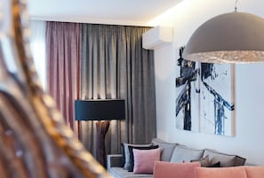A modern living room with a sofa, a floor lamp, and a large abstract painting on the wall.