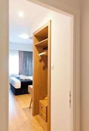 A hotel room with a bed, a wooden wardrobe, and a desk. - Acropolis Panoramic View Deluxe Apartment | 3 Falirou str 11742 Athens (Athina)