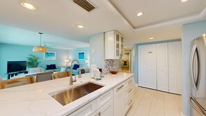 A modern kitchen with a marble countertop, stainless steel sink, and a built-in oven.