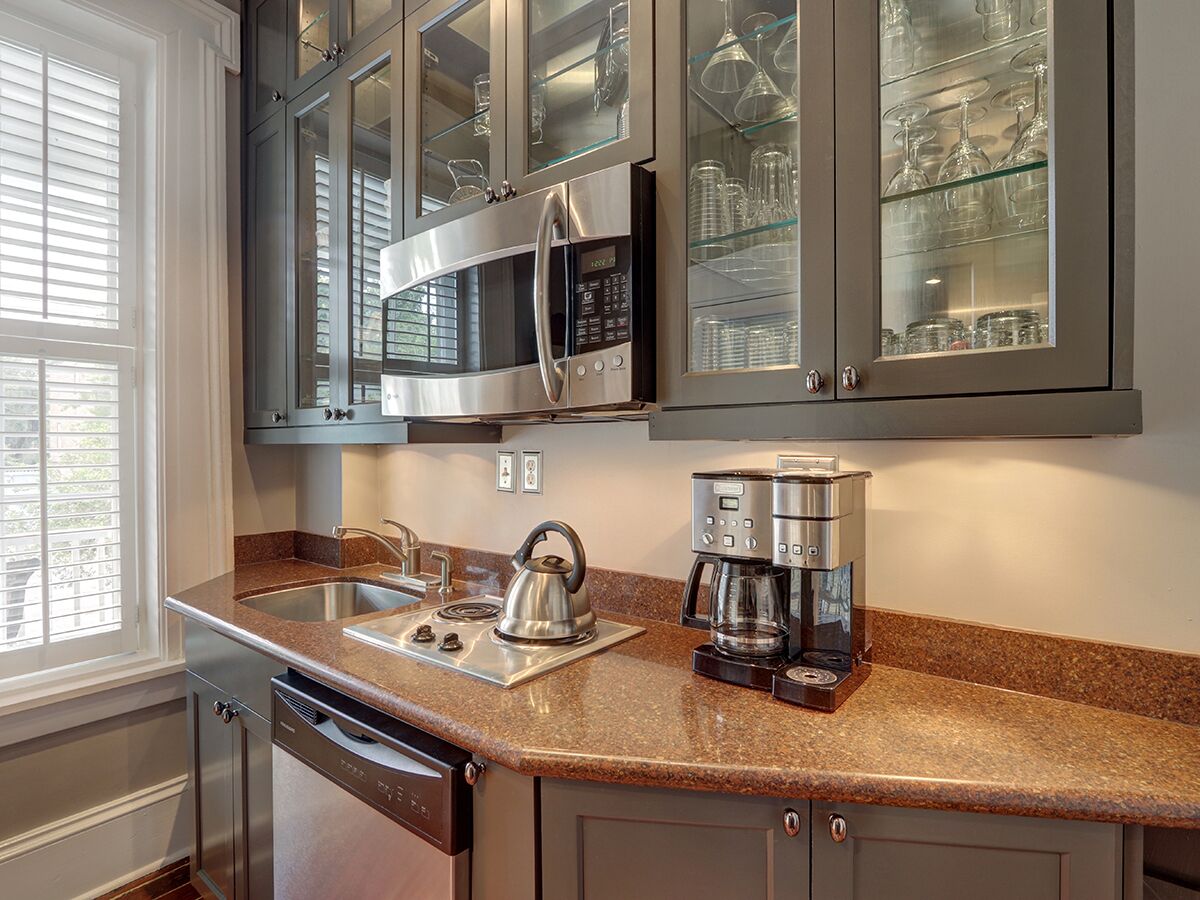 A kitchen with granite countertops, stainless steel appliances, and glass-fronted cabinets.