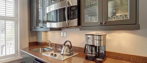 A kitchen with granite countertops, stainless steel appliances, and glass-fronted cabinets.