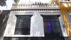 Un edifici amb façana blanca, finestres amb estructura negra i una porta negra.