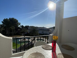 Enjoy a refreshing view of the pool from this balcony, complete with a table and chairs.