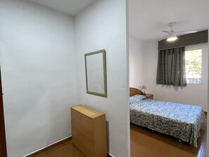 Cozy retreat with a single bed, nightstand, and dresser for a comfortable stay.