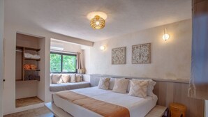 Ein Schlafzimmer mit einem großen Bett, eingebauten Regalen, einem Fenster mit Aussicht und Wandbildern.