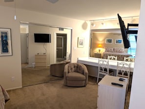 Ein Hotelzimmer mit Bett, Schreibtisch, Stuhl, Fernseher und Dusche.