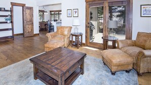 Amplia sala de estar con una mesa de centro de madera, sillones de cuero y una alfombra.