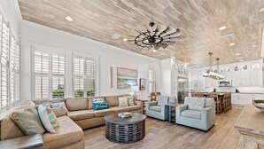 A spacious living room with a large sofa, a coffee table, and a dining area with chairs and a table. - ☀️ Sol Experience | Golf Cart & Heated Community Pool | FREE Golf (Miramar)