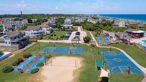 Luchtbeeld van een kustgebied met woonhuizen, een strand en een sportcomplex.