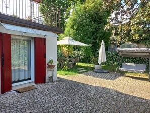 A patio with a table and chairs, a covered seating area, and a potted plant. - Le Magnolie 2 next to the bus stop (Venezia)