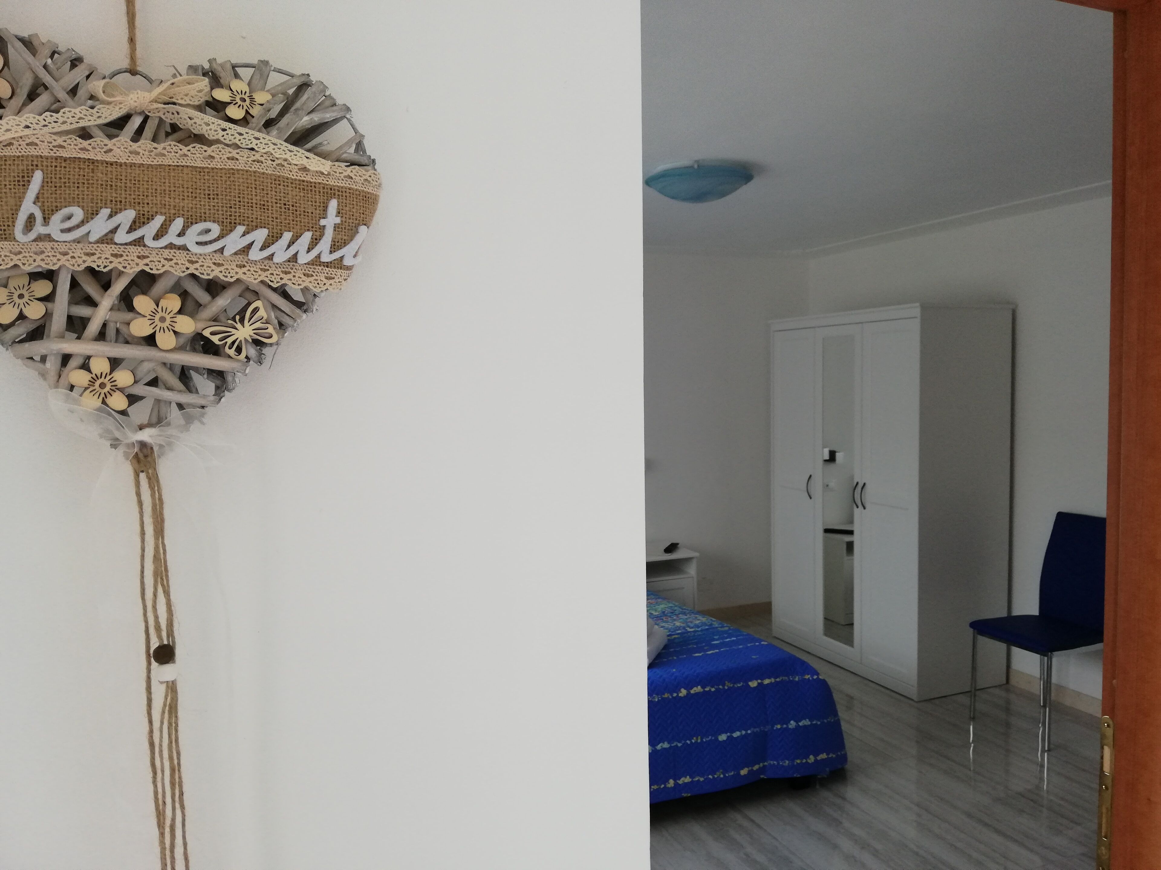 Una habitación con una cama, un armario y una puerta.