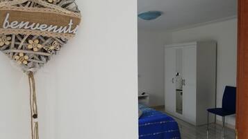 Una habitación con una cama, un armario y una puerta.