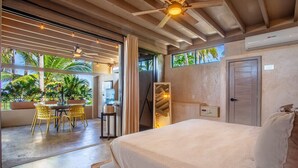 A bedroom with a bed, a ceiling fan, a window, and a door.