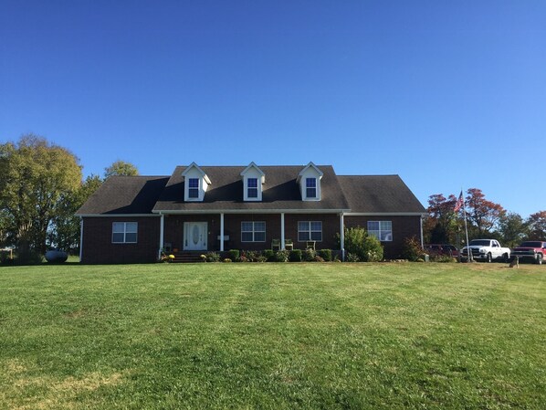 A two-story house with a front porch, a garage, and a well-maintained lawn.