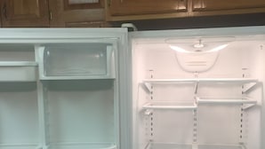 Ein offener Kühlschrank mit mehreren Regalen und einem Gefrierfach.