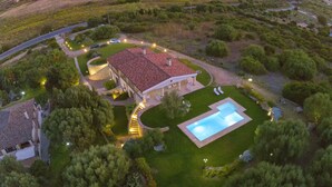Vue aérienne d’une propriété dotée d’une piscine, d’une allée sinueuse et d’une pelouse bien entretenue.