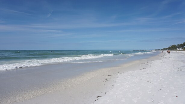 A beach with white sand and clear blue water. - Fall Specials Available! Pet Friendly! Steps to white sandy beaches and the bay!  Discounts applied for stays longer than 7 days and 30 days! (Bradenton Beach)