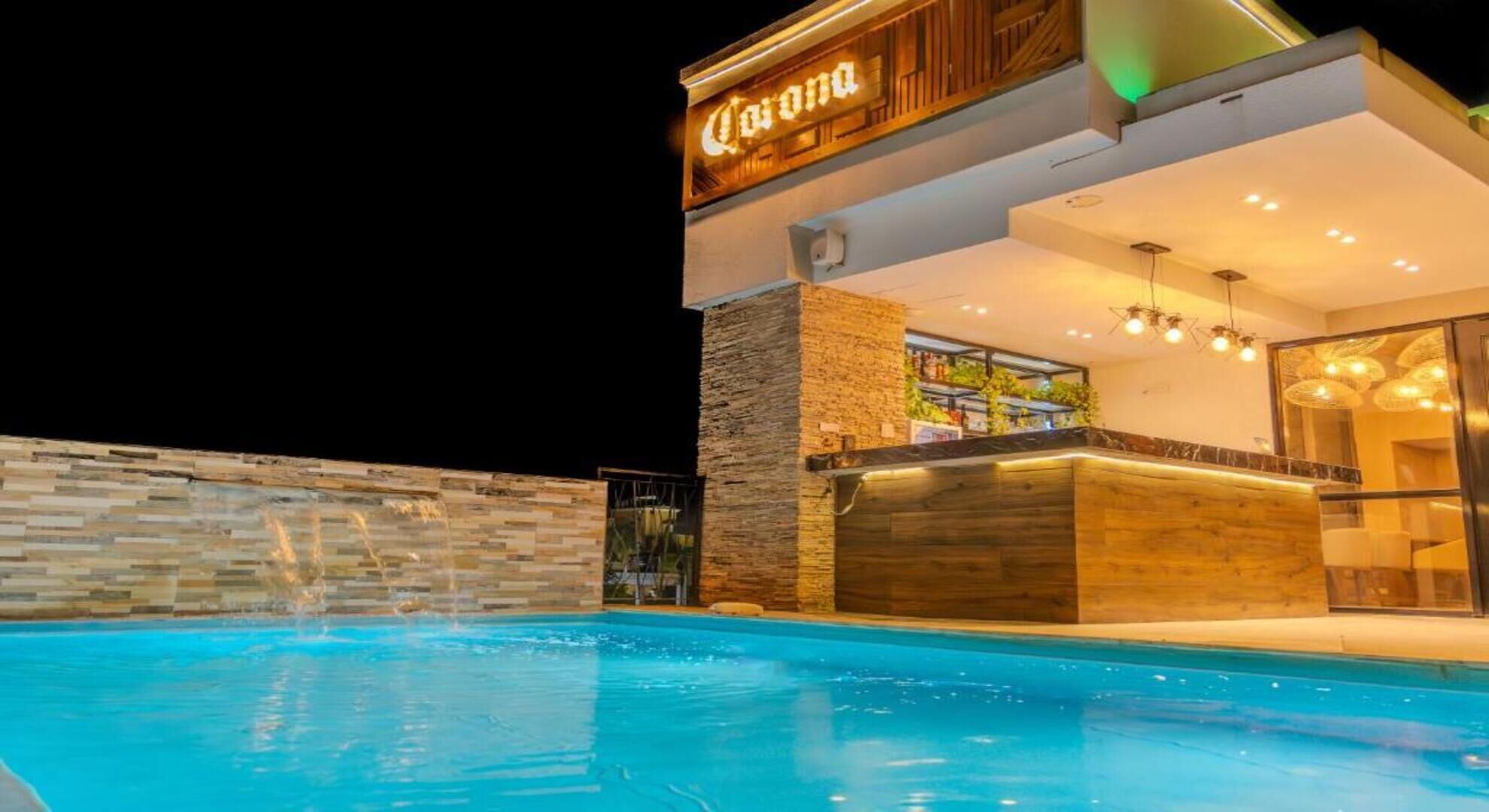 Ein Hotel mit Schwimmbad, Barbereich und einem Schild mit der Aufschrift 'Corona'.