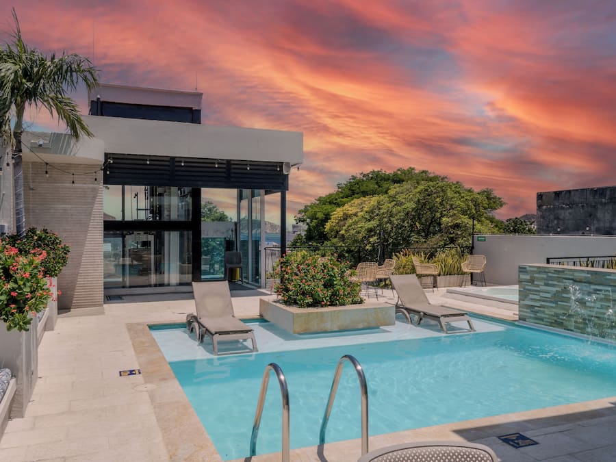 Una piscina al aire libre, sillones reclinables de piscina