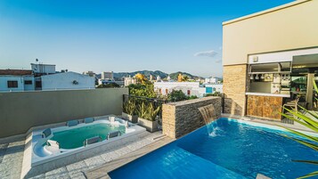 Una piscina al aire libre, sillones reclinables de piscina