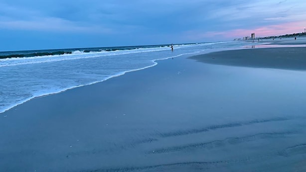 Une plage avec une vaste étendue de sable et des vagues douces.