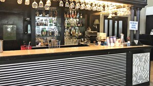 A bar area with a counter, shelves of bottles, and a sign indicating ice for sale. - Royale Tagaytay B&B (Alfonso)