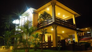 A two-story building with a balcony, surrounded by greenery. - Lotus Seaview Beach Resort (Bandar Penawar)