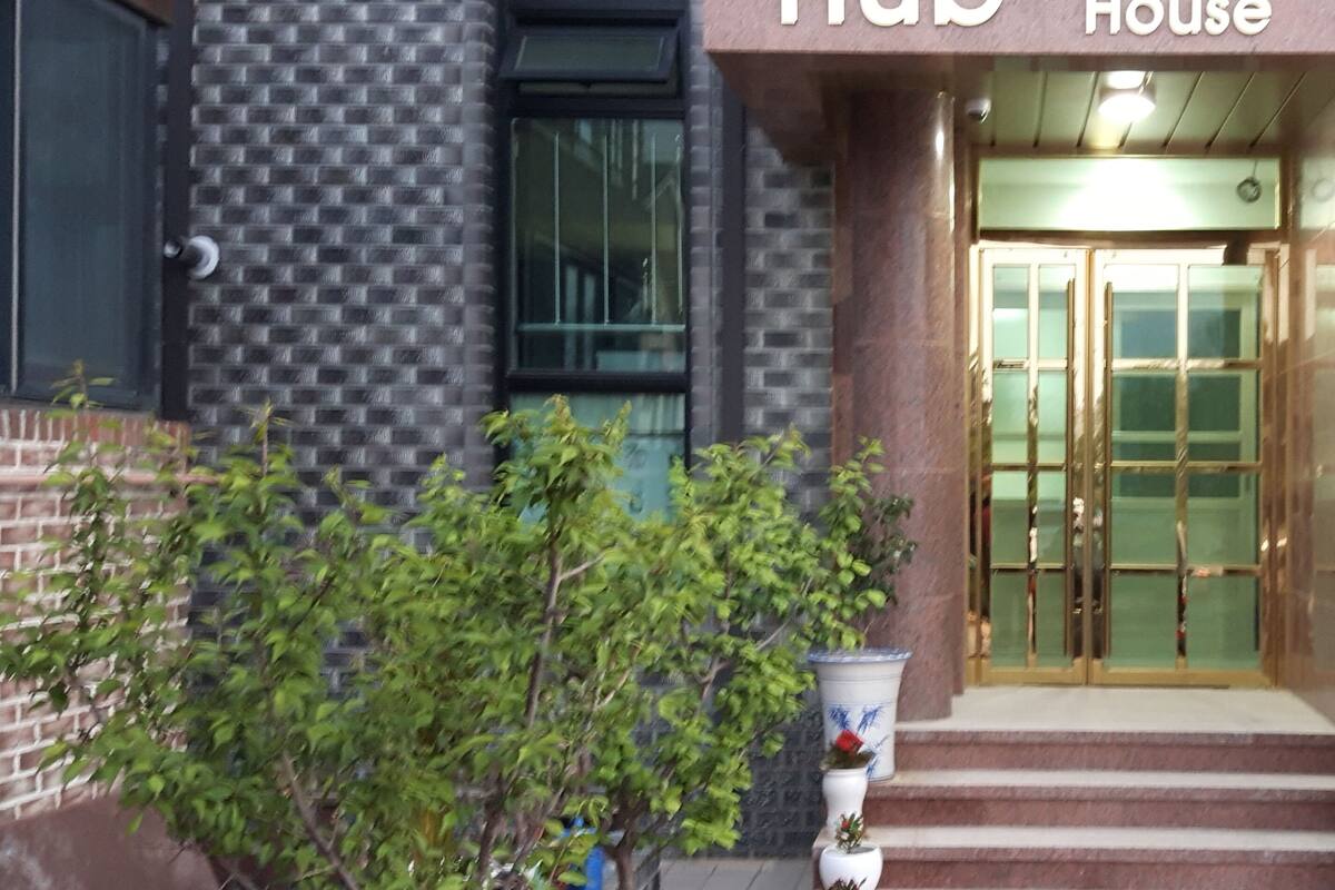A building entrance with a sign reading "Hub Guest House".