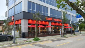 A modern building with a cafe named 'CAFFE PASCUCCI' on the ground floor. - Hub Guest House (Incheon)