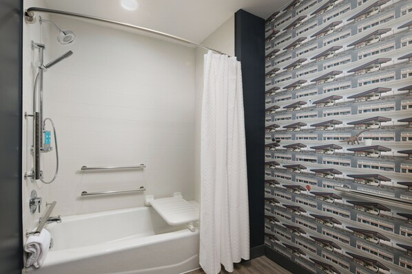 Un baño moderno con bañera, ducha y toallero.