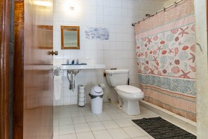 Une salle de bain avec des toilettes, un lavabo et un rideau de douche.