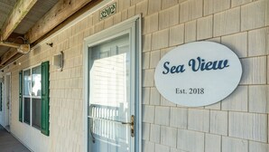 Un bâtiment dont la façade porte une enseigne indiquant « Vue sur mer » et « Fondé en 2018 ».