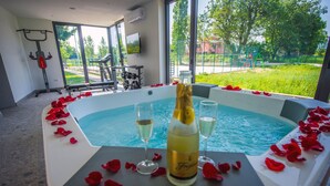 A spa area with a hot tub, rose petals, champagne, and glasses. - LUXURY 7 BEDROOM VILLA  WITH PRIVATE POOL,TENNIS COURT,GYM AND SPA (Donji Proložac)