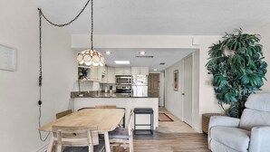Eine moderne Küche mit weißen Schränken, einem Holzespeisetisch und einem eingebauten Backofen.
