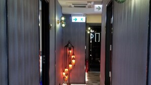 A hallway with patterned flooring, a decorative ceiling, and directional signs.